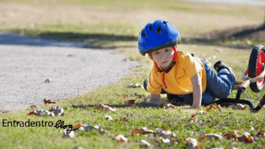 un bambino caduto a terra vicino alla sua bici